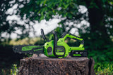 Greenwood cordless chainsaw with a bright lime green and black body, resting on a tree stump with a blurred outdoor forest background.